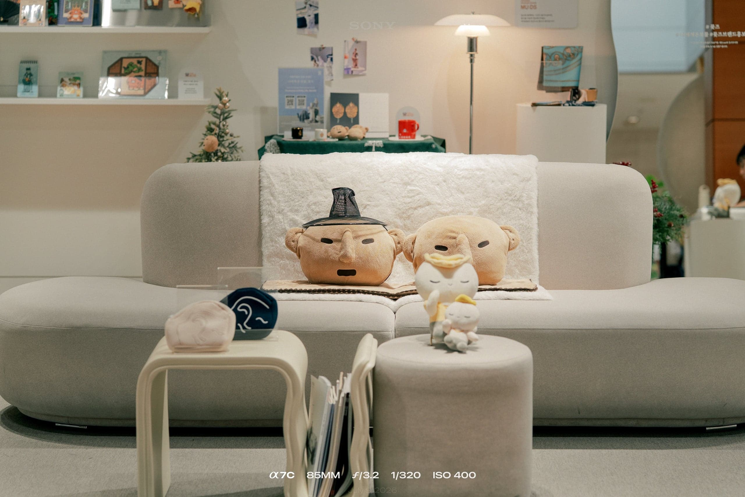 돌사람 얼굴 쿠션과 반가사유상 인형이 놓인 뮷즈 라운지